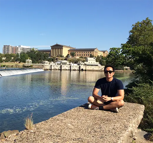 a photo of aiman at the schuykill river in front of art museum